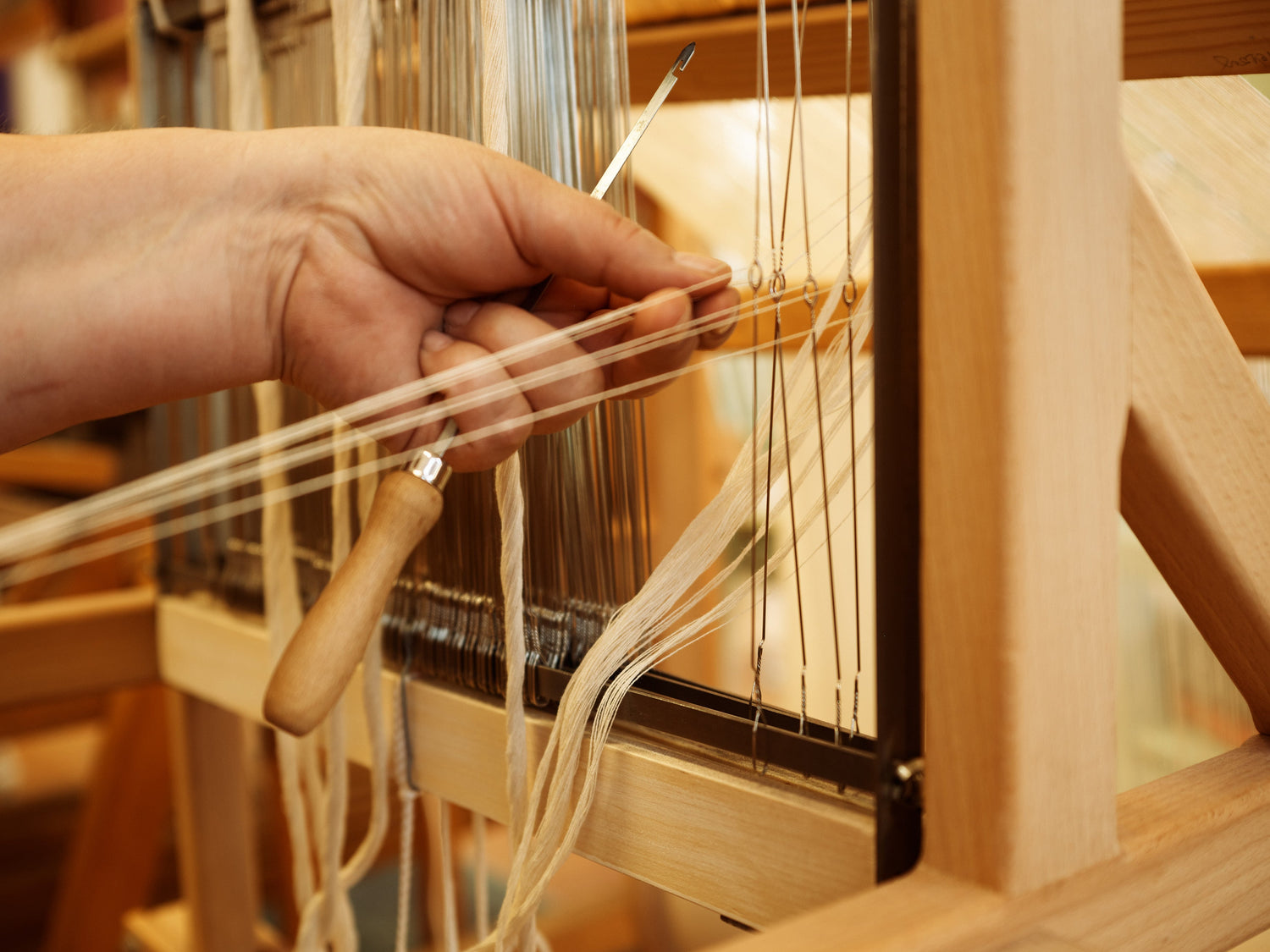 Felvetőszálak nyüstbe fűzése kéziszövéshez.